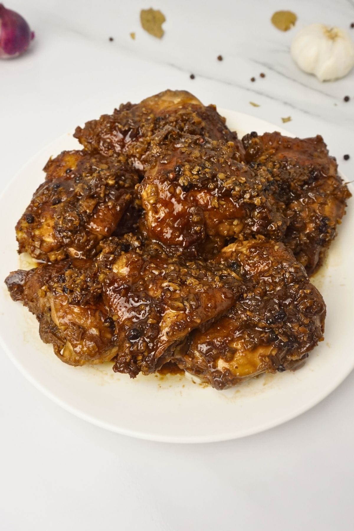 Chicken adobo serve in a round white plate.