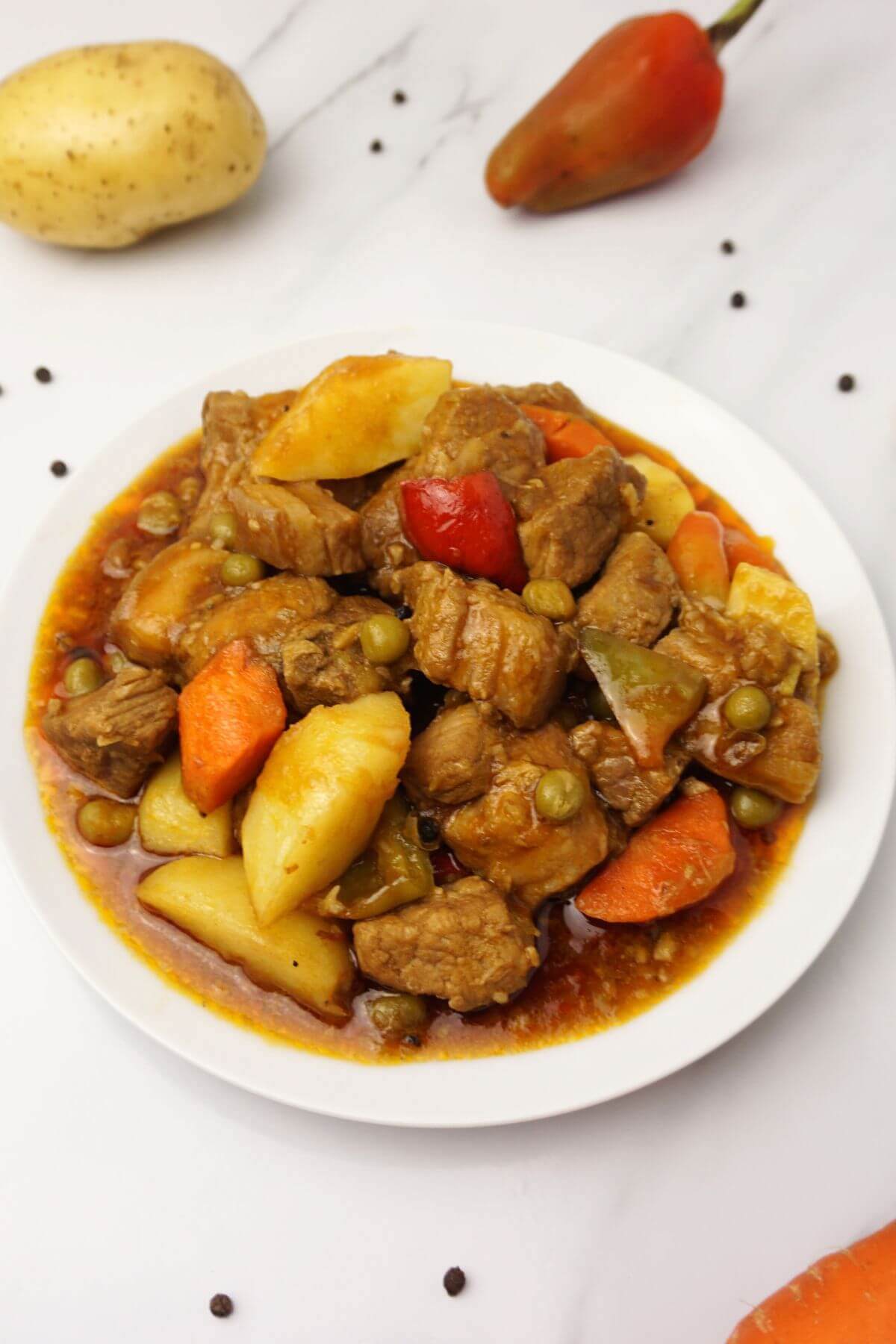 Pork mechado with red bell peppers, carrots and potatoes.