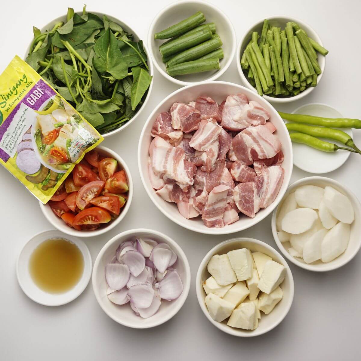Pork sinigang ingredients in bowls.