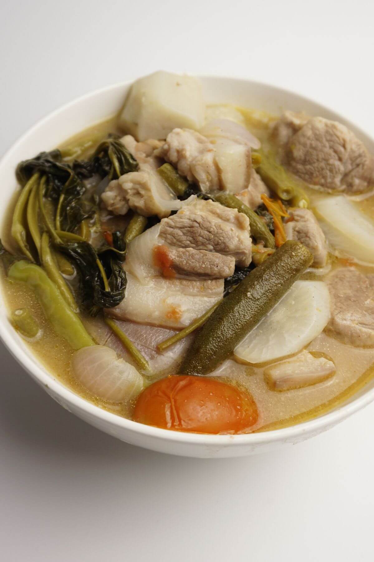 Bowl of pork sinigang with kangkong leaves and okra.