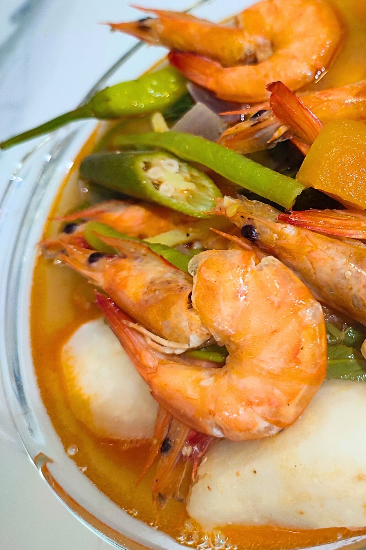 Bowl of shrimp sinigang with okra, kangkong and green chili.