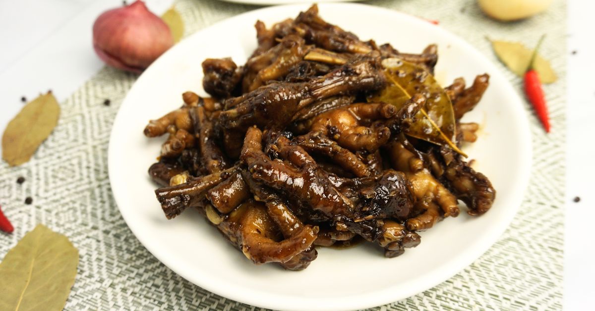 Adobong paa ng manok in a plate with spices on the table.