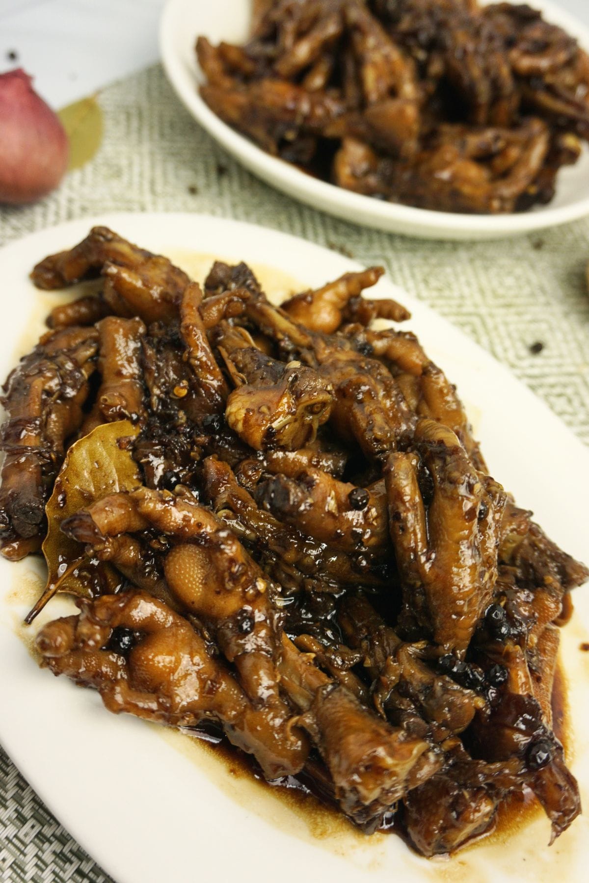 Saucy chicken feet adobo in an oval plate.