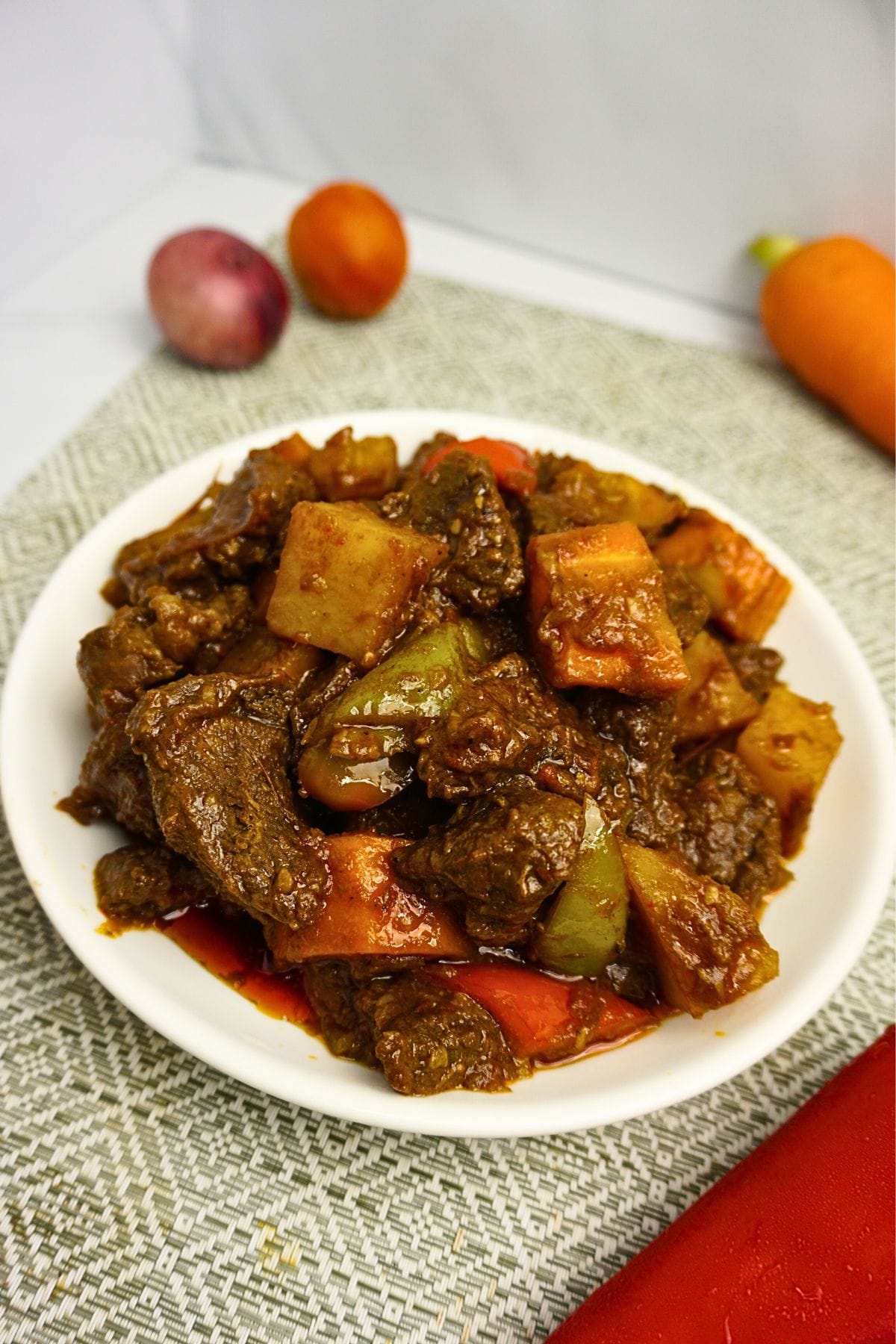 Beef cooked in tomato sauce with carrots, bell peppers and potatoes.