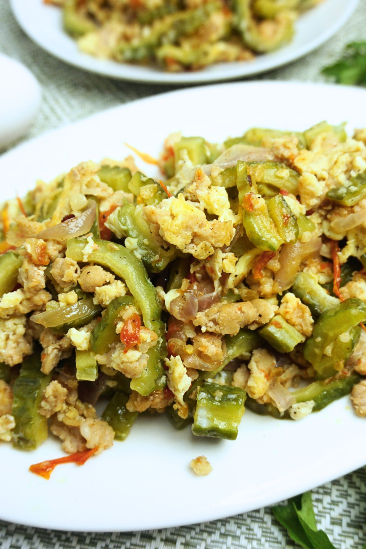 Ginisang ampalaya with egg served in a white oval plate.