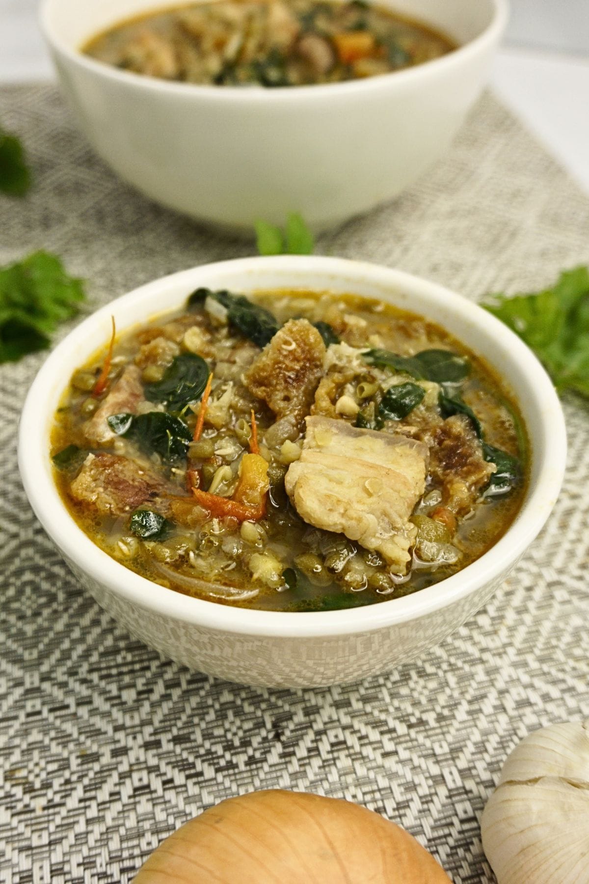 Bowls of ginisang monggo with pork and chicharon.