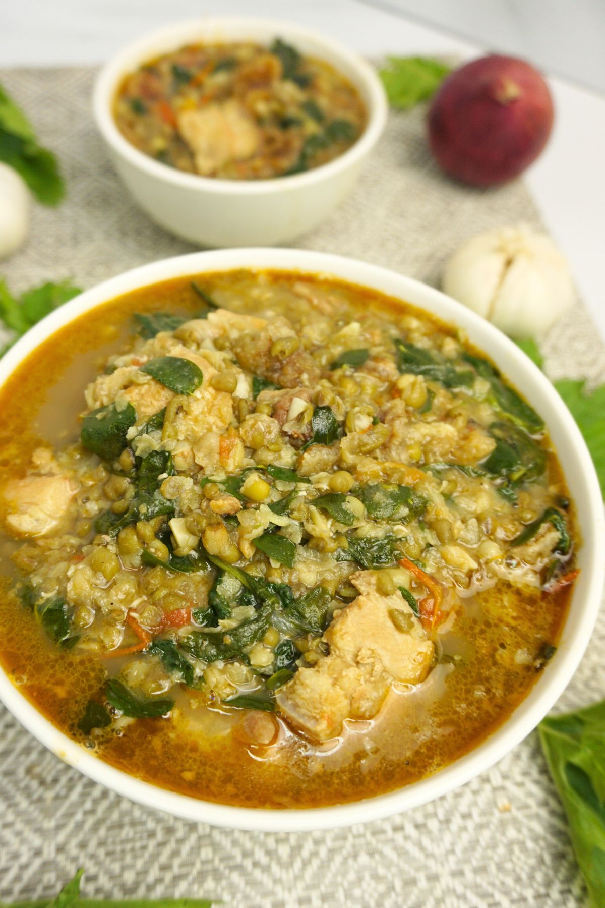 Serving of ginisang munggo in a white bowl.