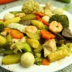 Plate of chopsuey in a table with fresh vegetables.