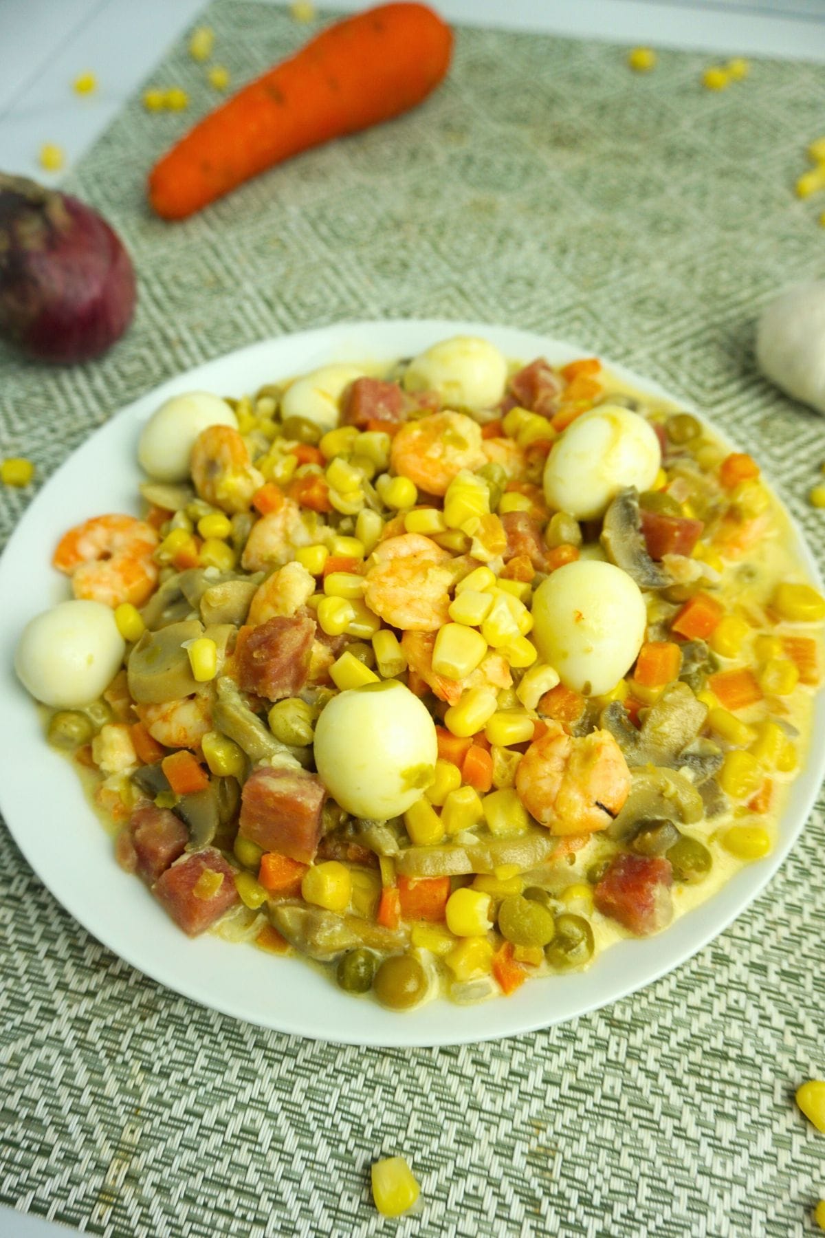 Creamy quail eggs with carrots, green peas and corn kernels.