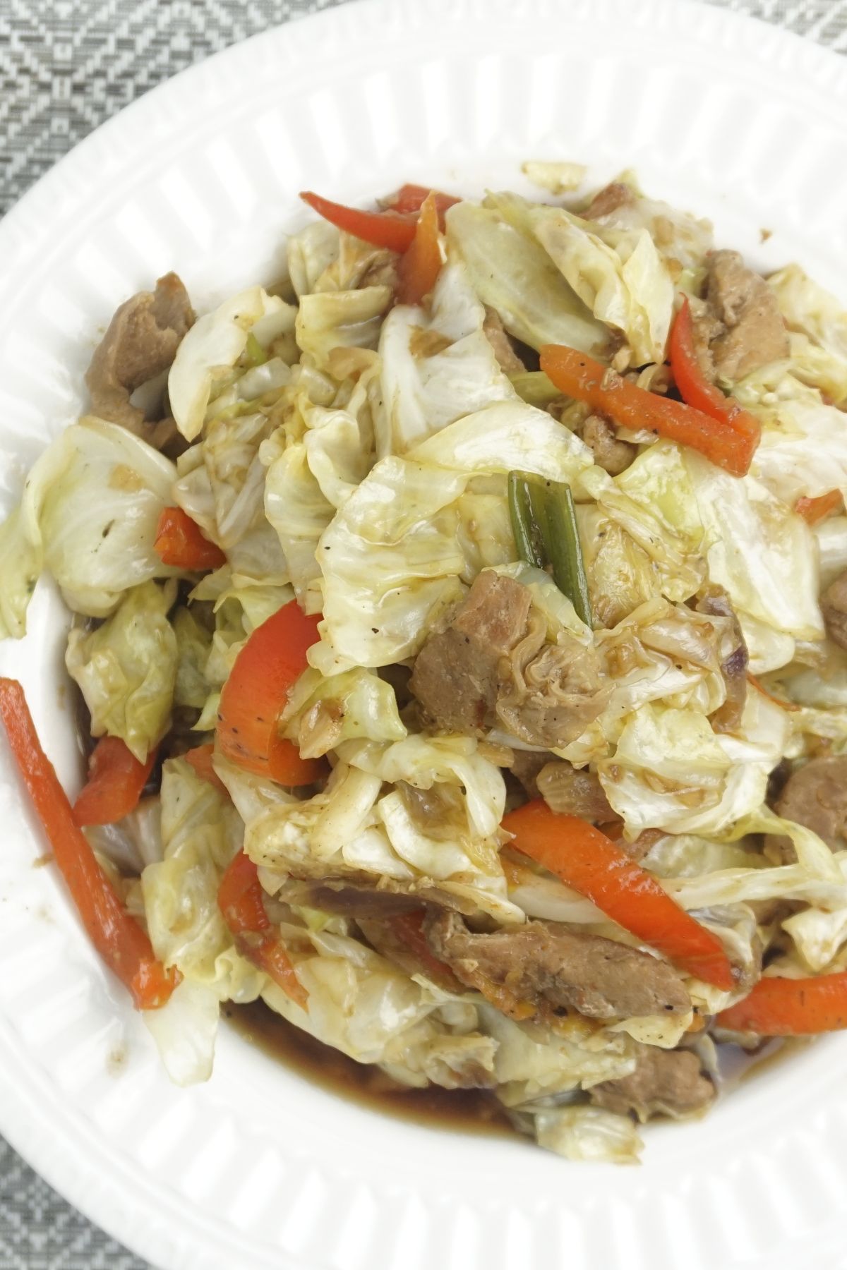 Cabbage with pork serving in a white plate