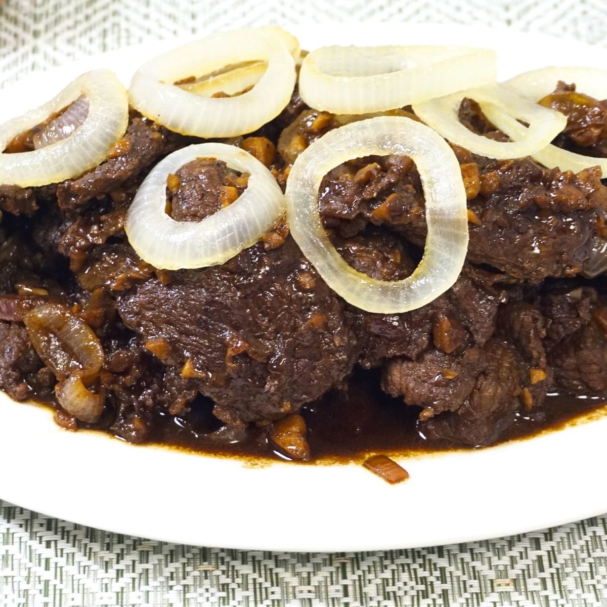 Bistek tagalog garnished with onion rings.