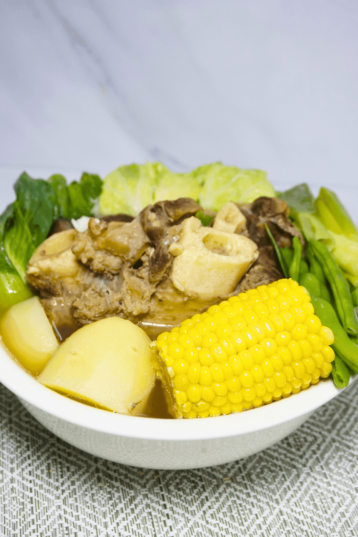 Bulalo soup with potatoes, corn and green beans.