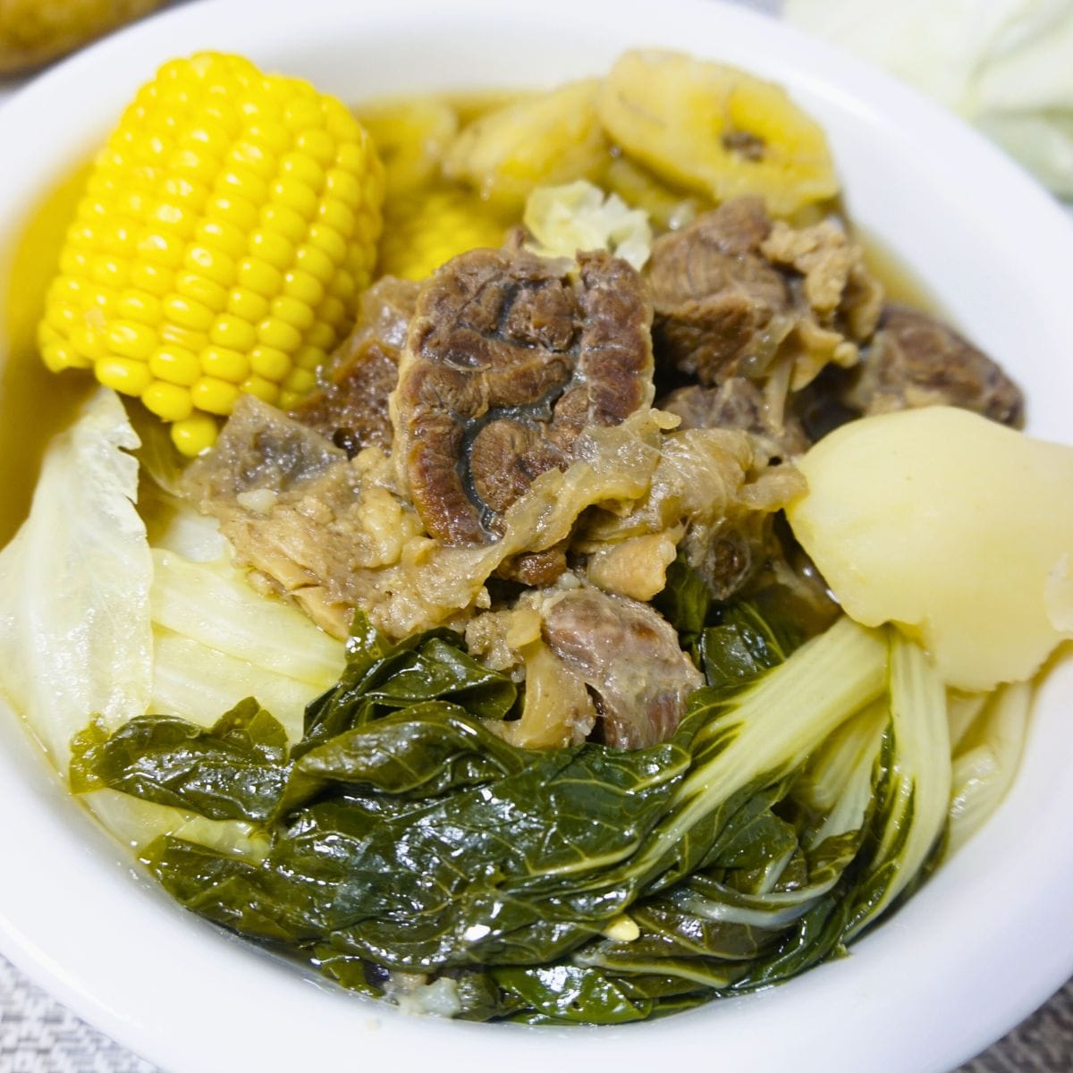 Beef shanks soup with sweet corn, sweet plantain, potatoes, cabbage and pechay.