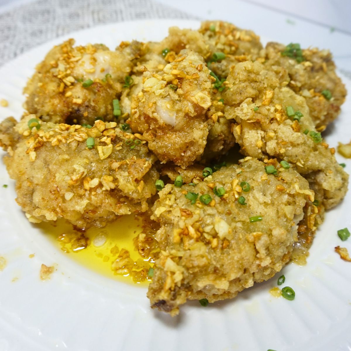 Plate of garlic buttered chicken garnished with spring onions.