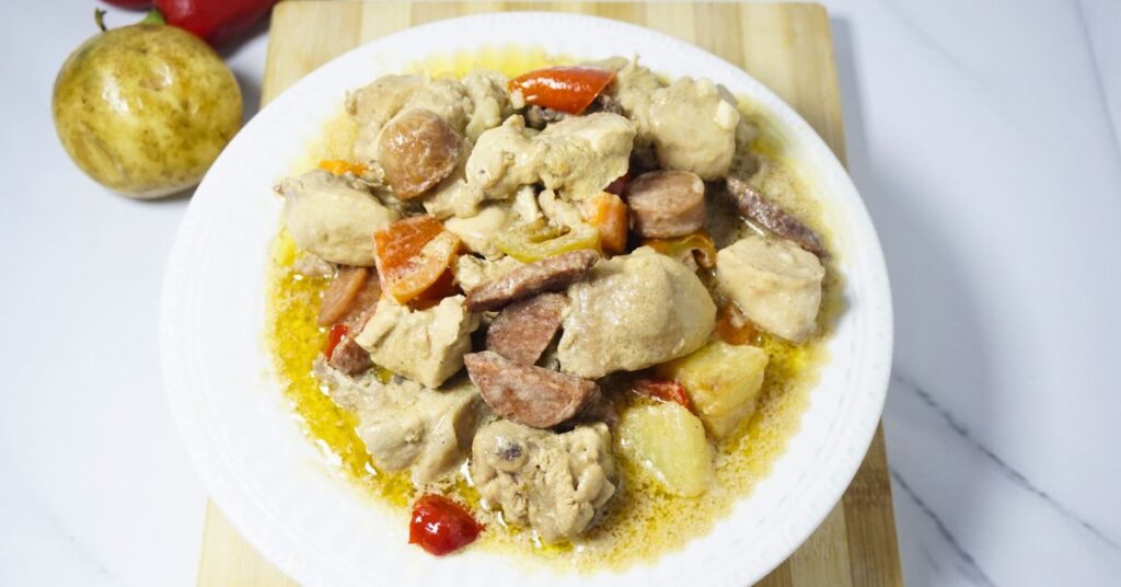 Plate of chicken pastel on a wooden chopping board.