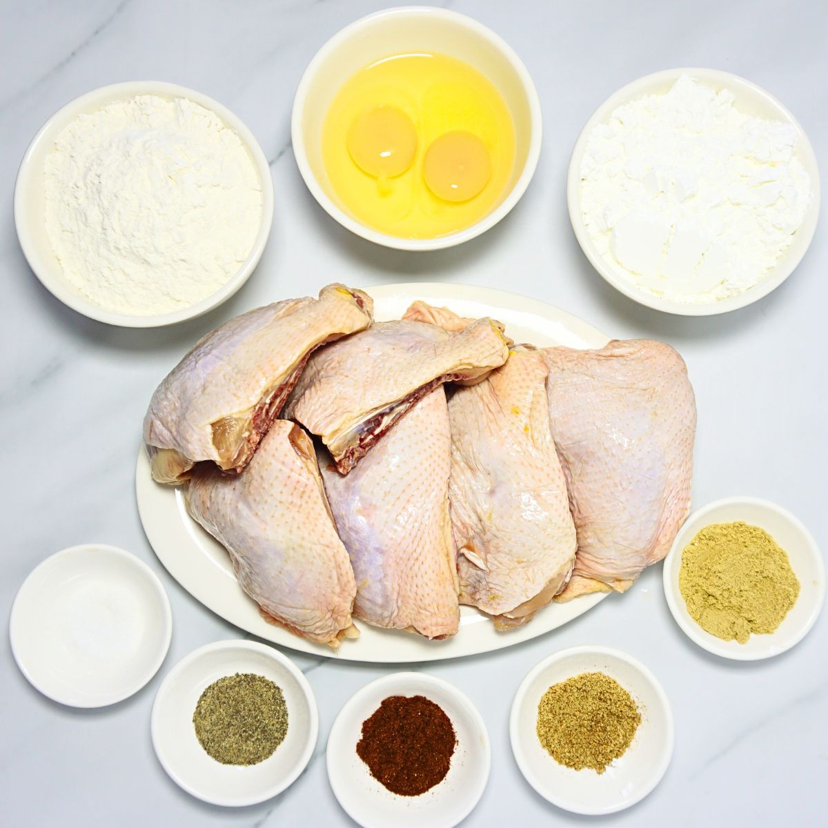 Fried chicken ingredients. Chicken slices, flour, eggs, cornstarch, chicken powder, salt, paprika, garlic powder and ground black pepper.