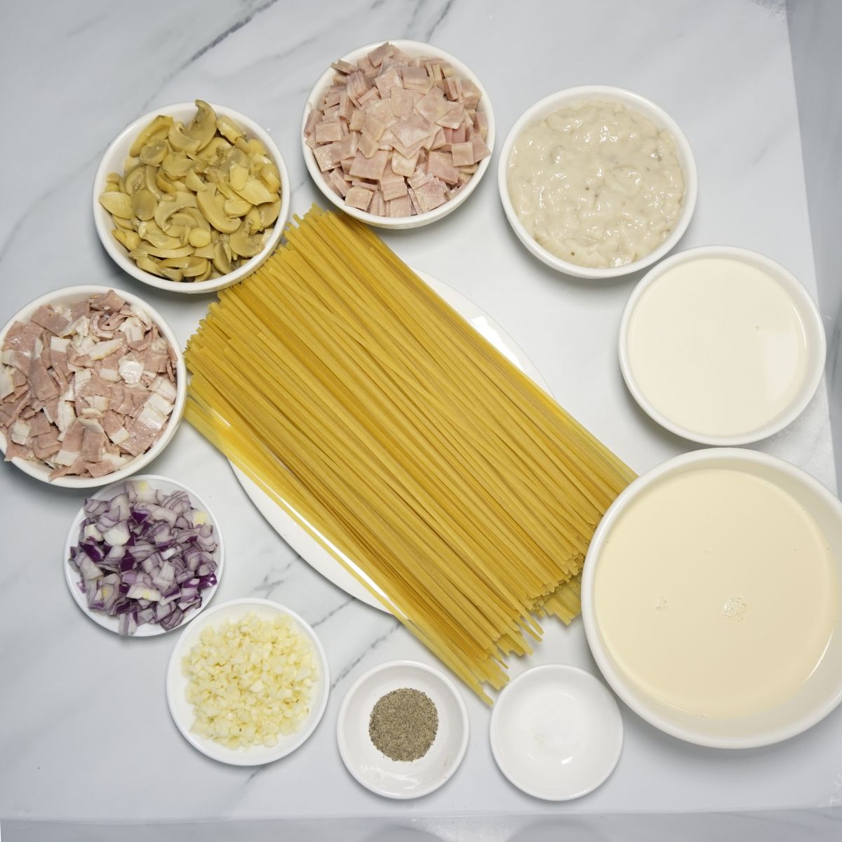 Filipino style carbonara ingredients. Pasta, garlic, onion, bacon, mushroom, ham, all-purpose cream, evaporated milk, cream of mushroom, salt and pepper.