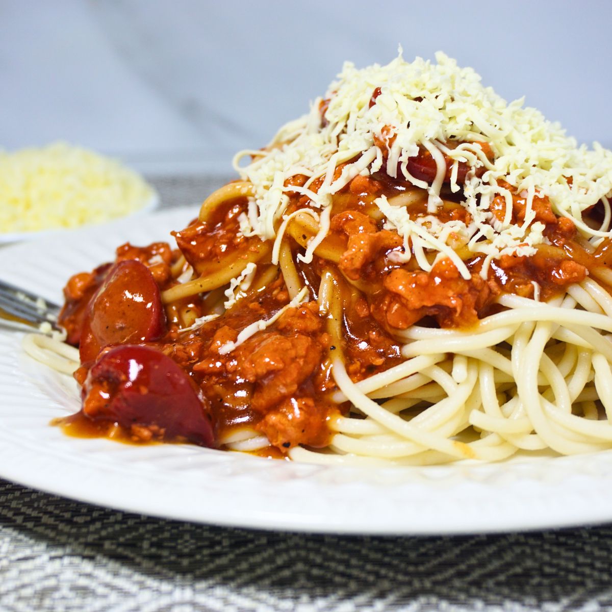 Saucy spaghetti topped with grated cheese.