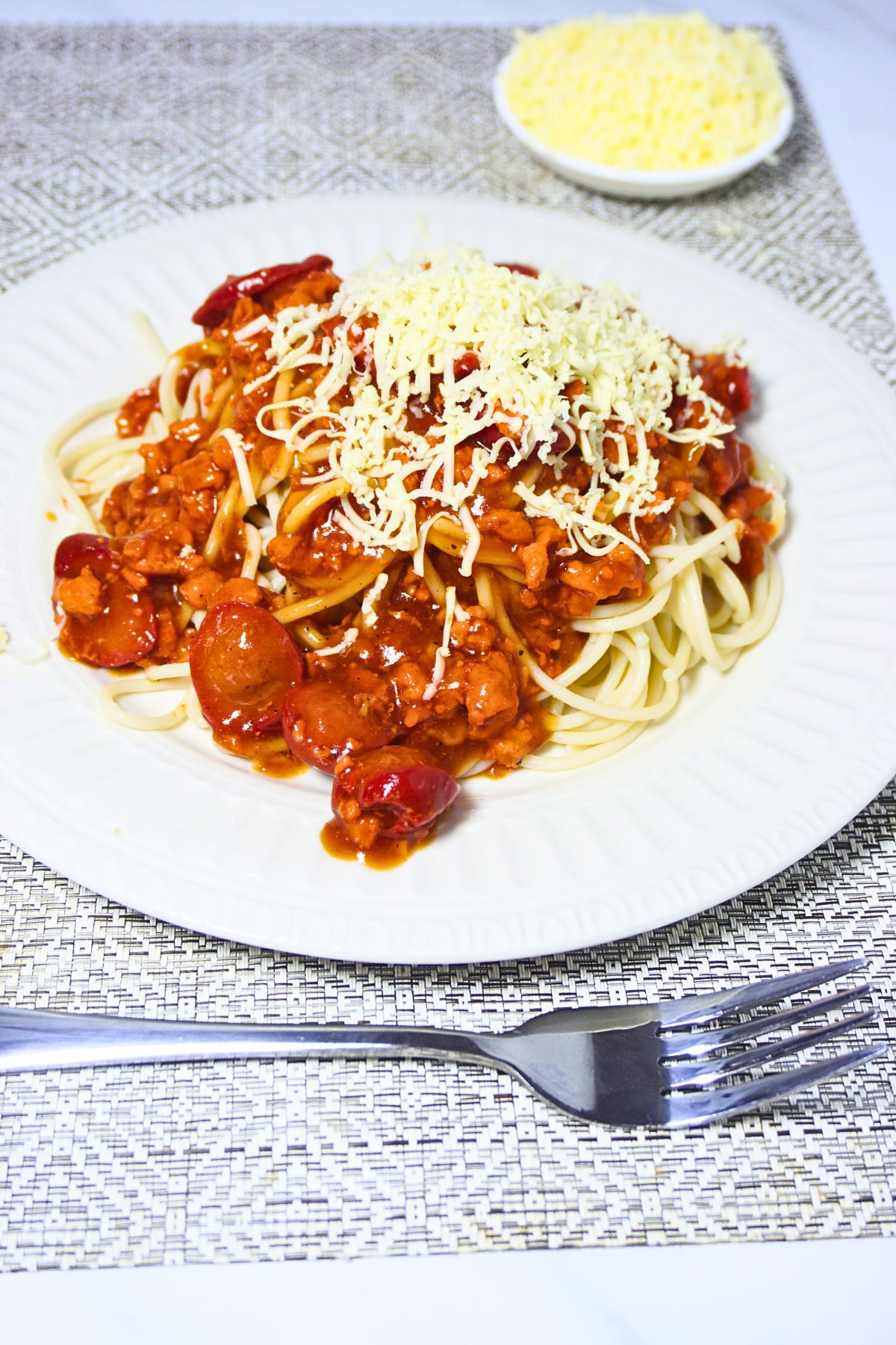 Pasta with sauteed tomato sauce and garnished with grated cheese on top.