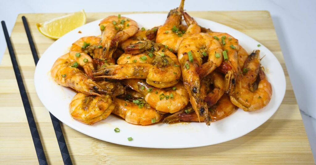 Garlic buttered shrimp on an oval plate.