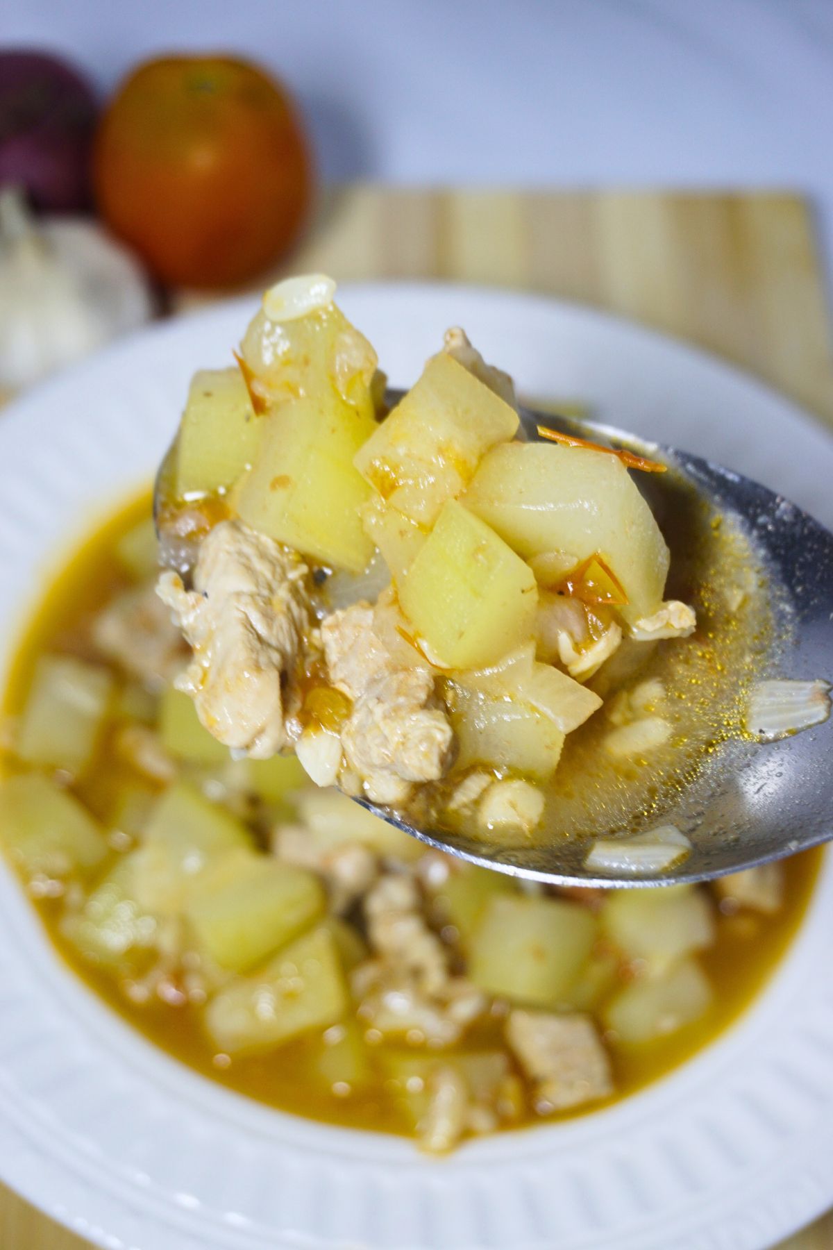 Spoon scooping a portion of sauteed bottle gourd.