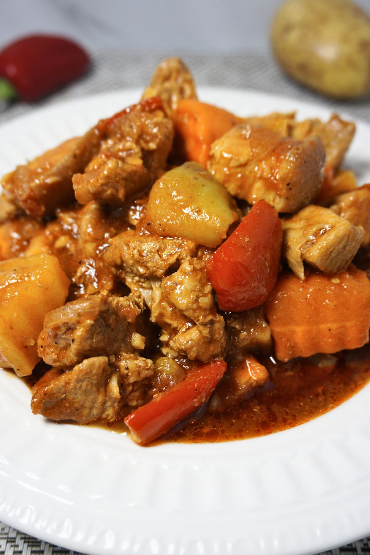 Pork belly sauteed in tomatoes with potatoes, carrots and bell peppers.