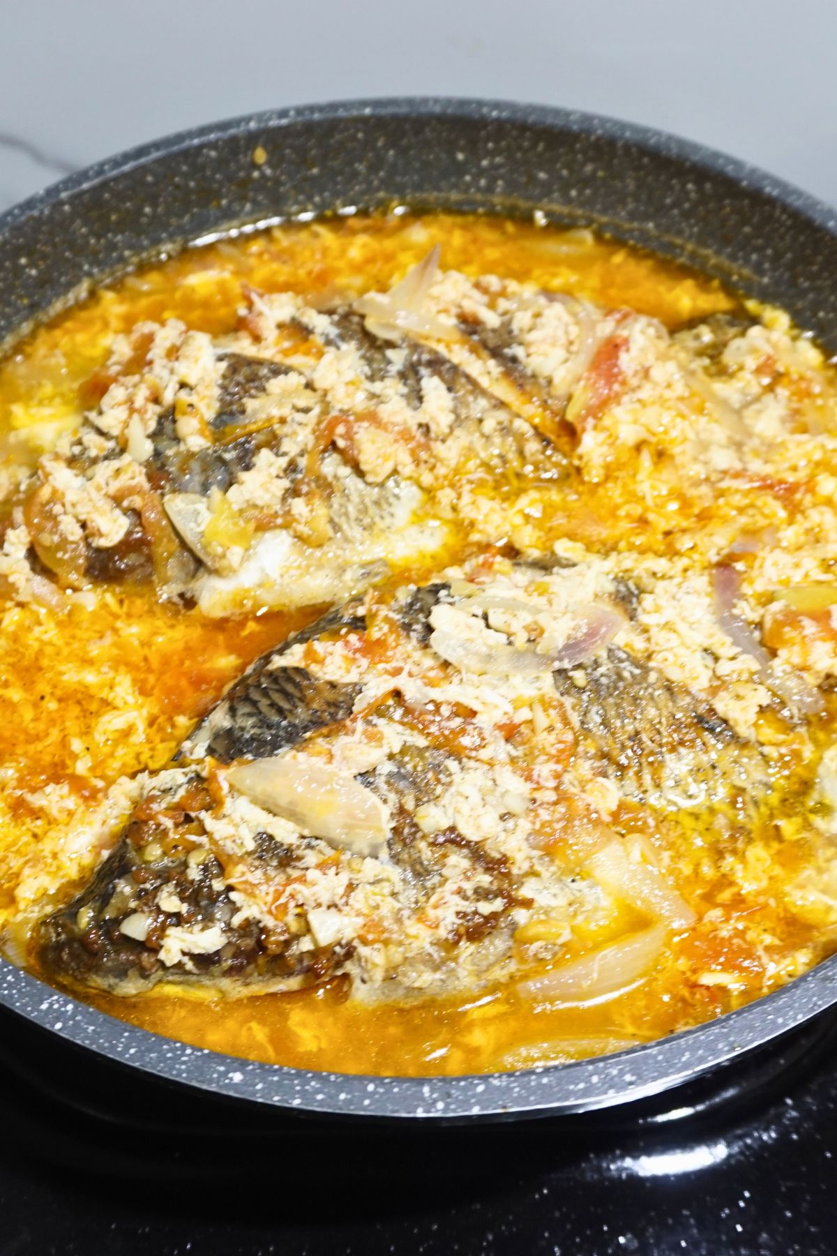 Sarciadong tilapia in a pan.