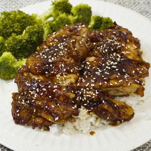 Plate of chicken teriyaki with steamed broccoli on the sides.