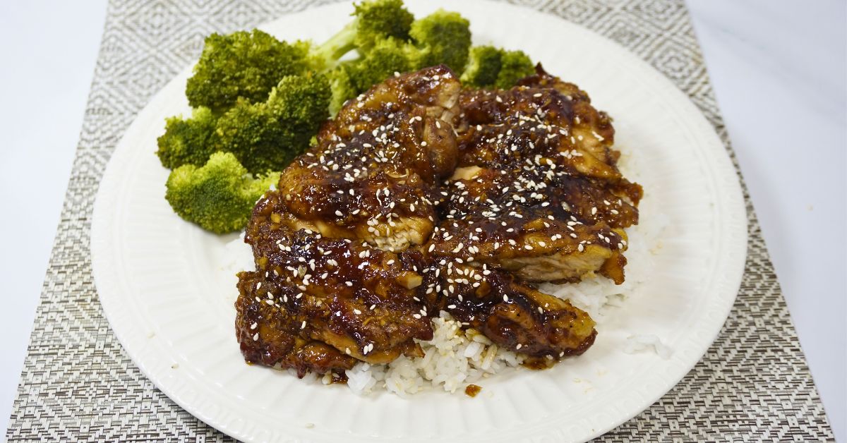 Plate of chicken teriyaki with steamed broccoli on the sides.