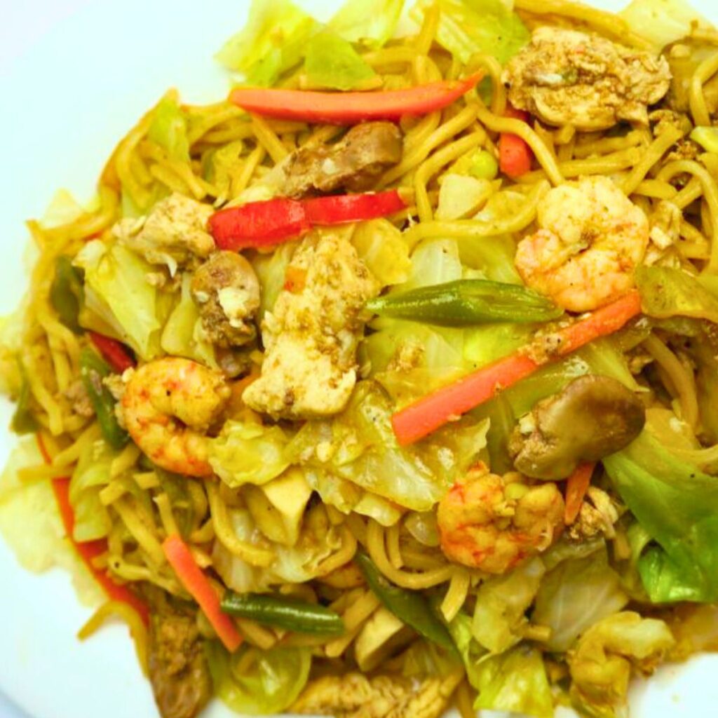 Overhead shot of pancit na canton served in a white plate.