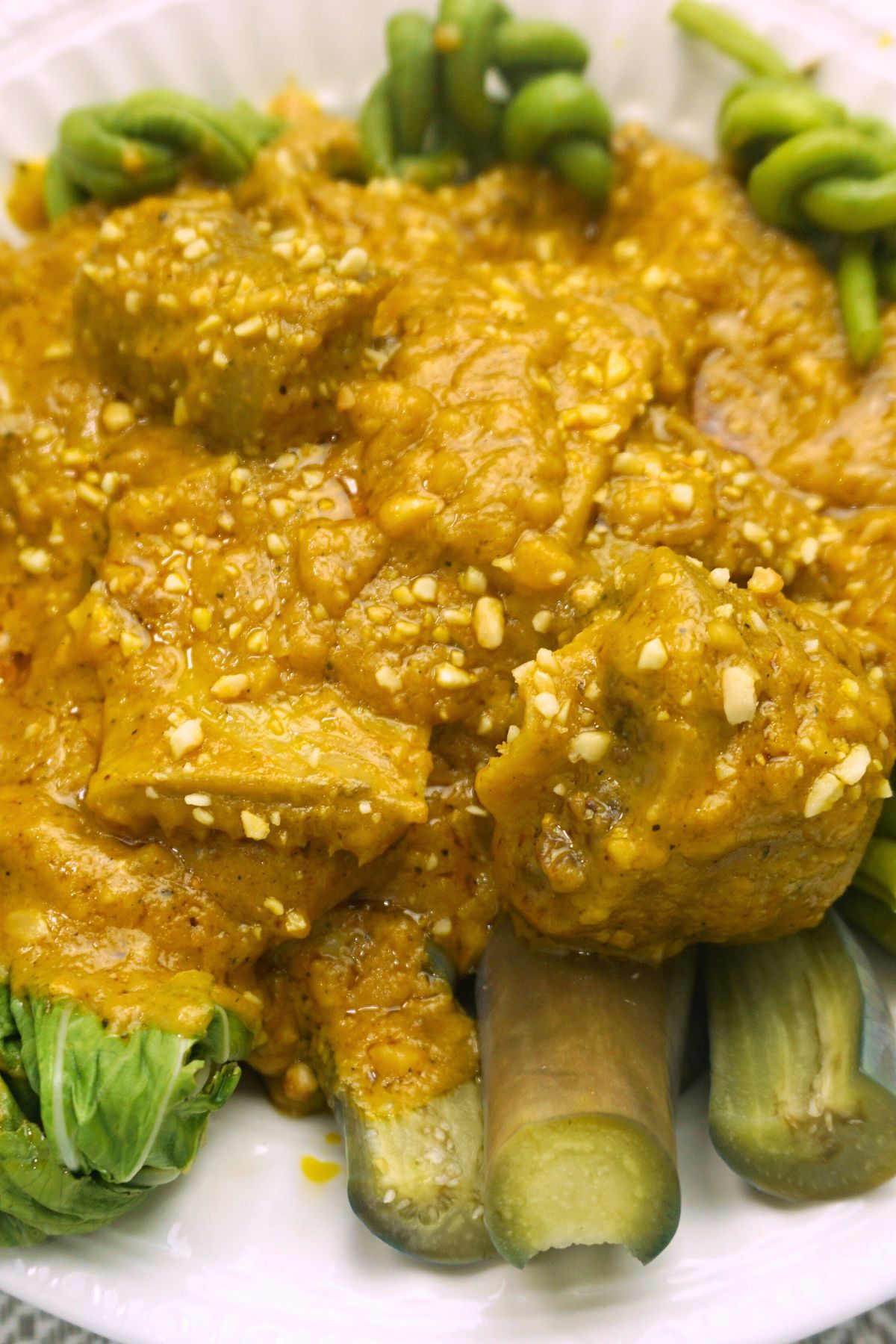 Beef kare kare serving in a white bowl