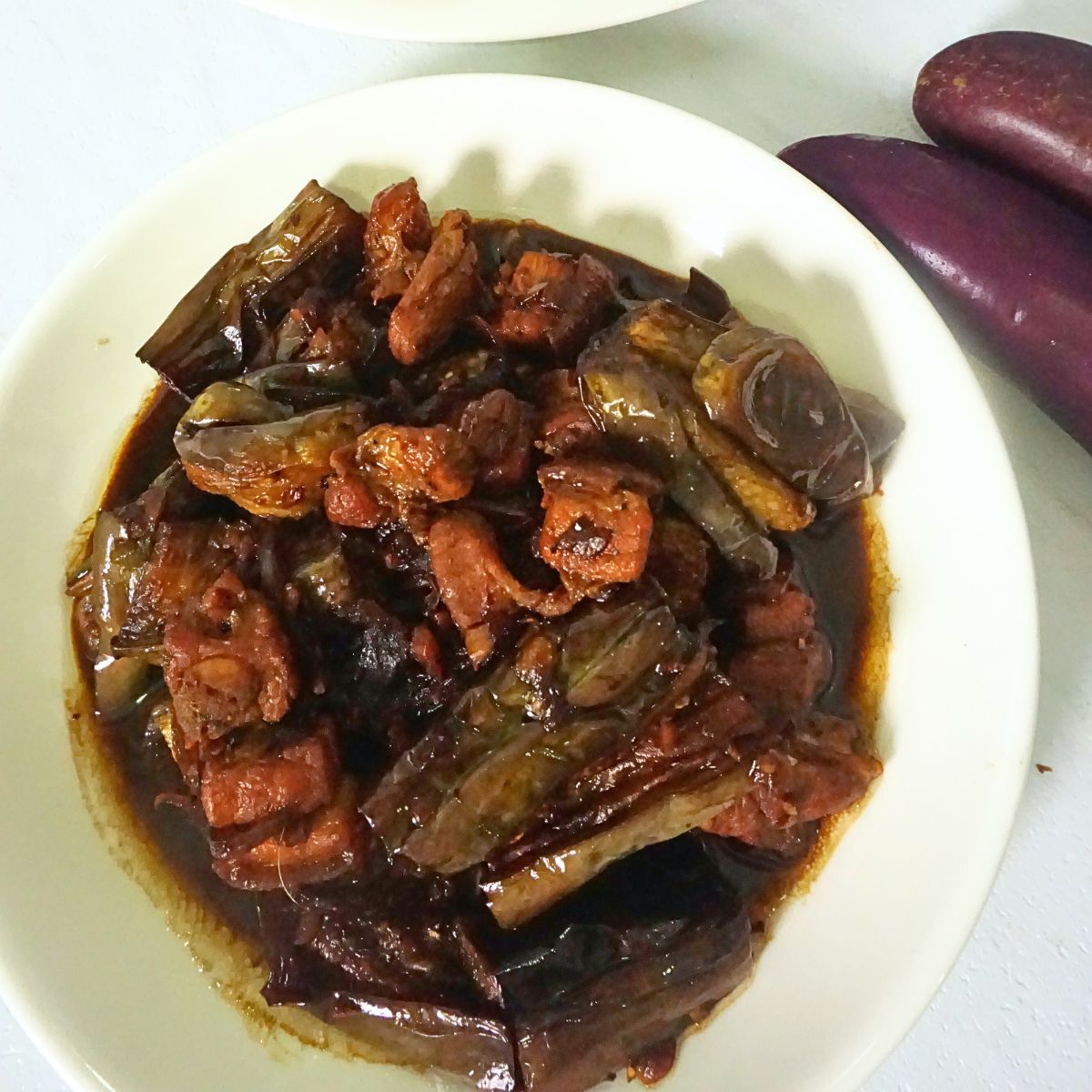 Overhead shot of adobong talong in a white plate.