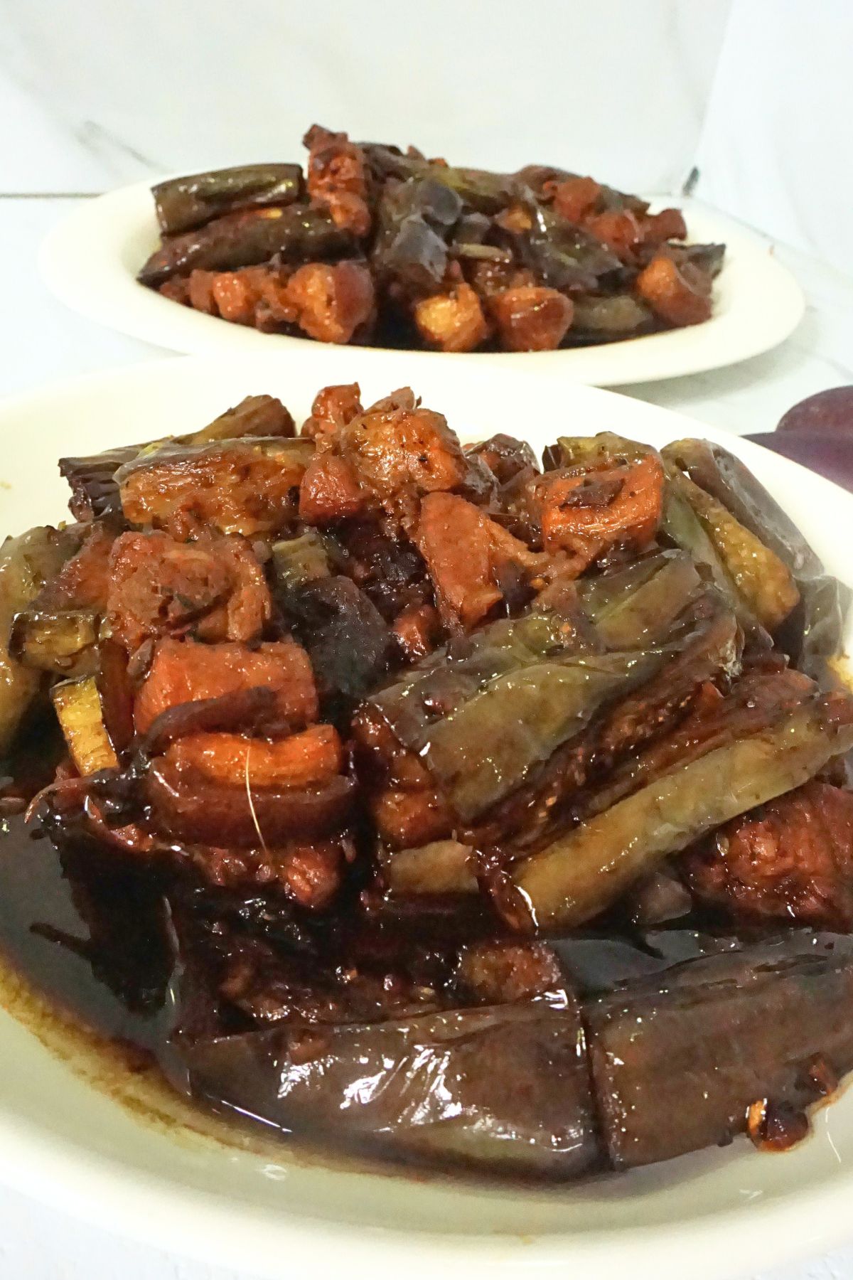 A serving of savory adobong talong with pork slices.
