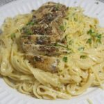 A serving of freshly cooked chicken alfredo.