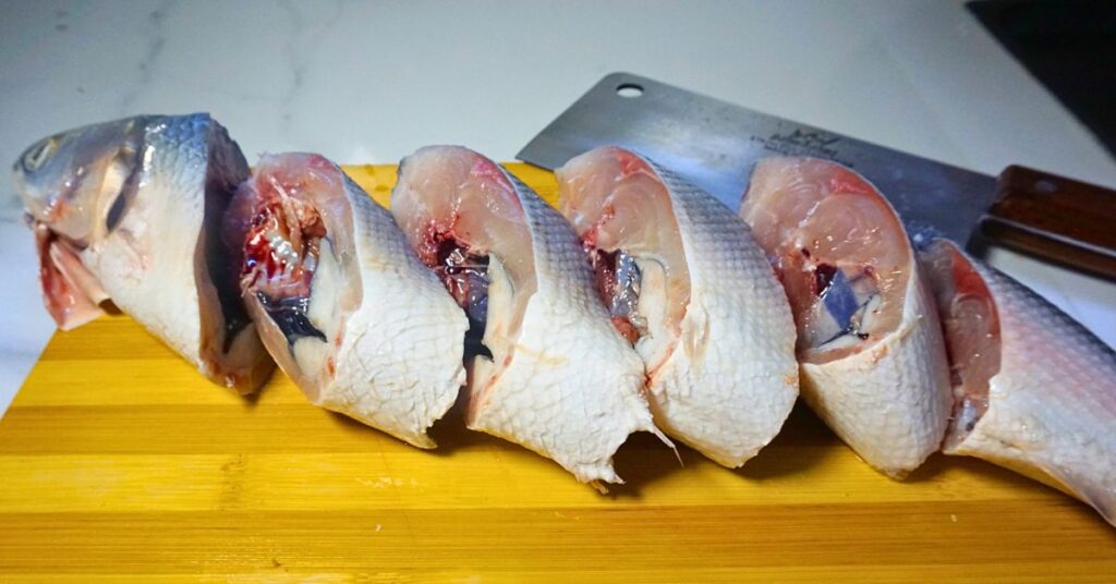 Sliced bangus(milkfish) in a wooden chopping board.