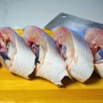 Sliced bangus(milkfish) in a wooden chopping board.