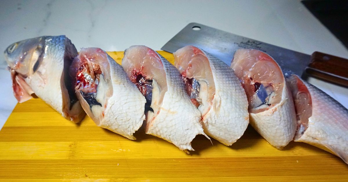 Sliced bangus(milkfish) in a wooden chopping board.