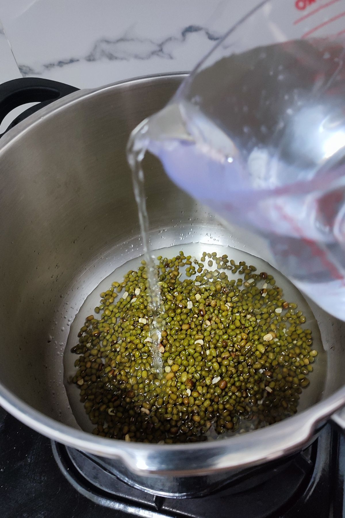 Pouring water on mung beans inside air fryer