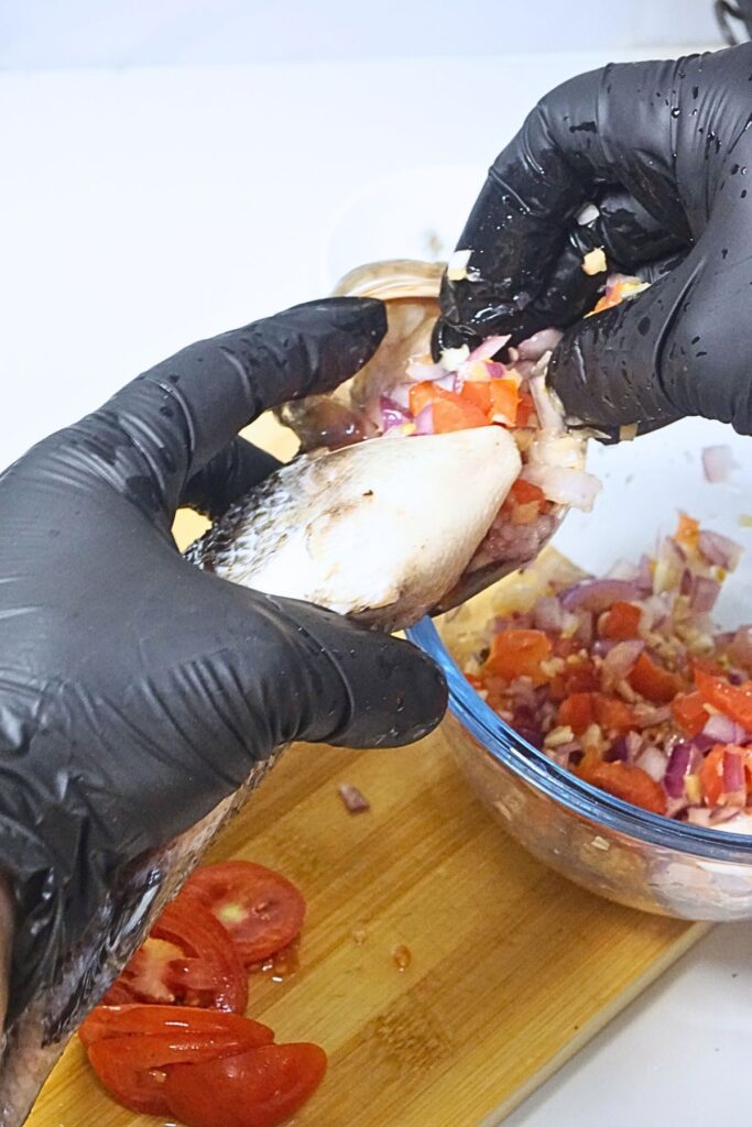 Stuffing sliced ingredients inside tilapia