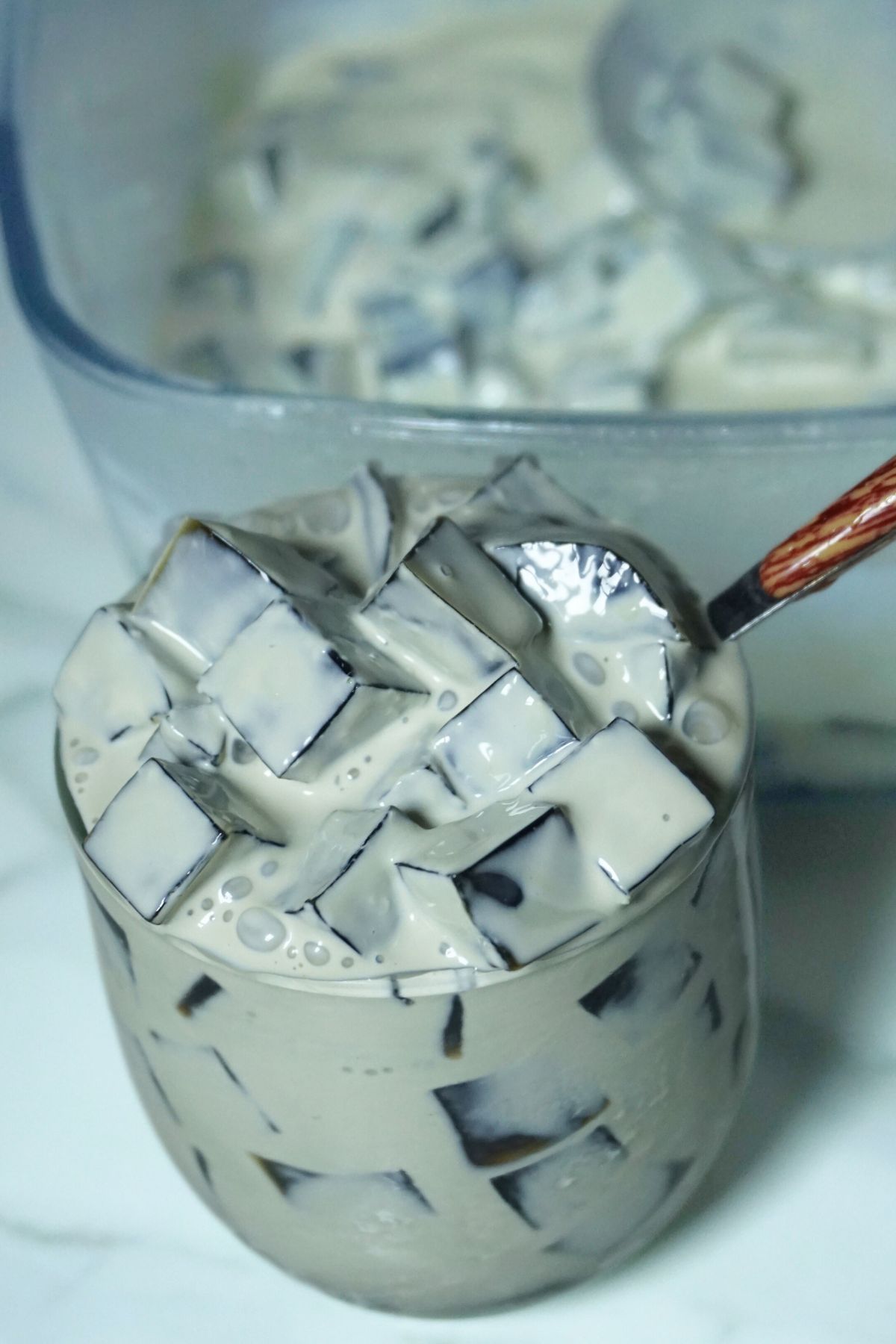 A serving of creamy coffee jelly in a glass cup