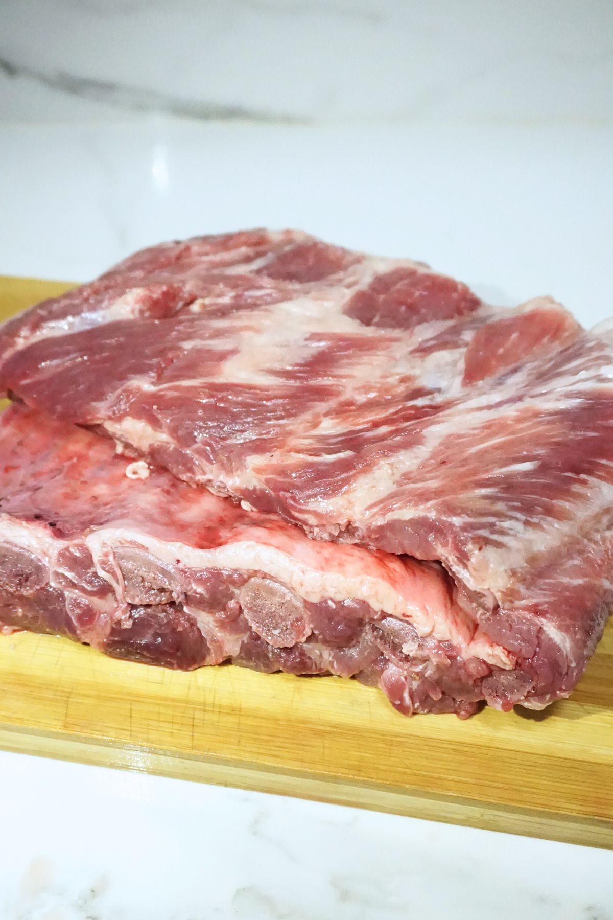 Fresh spare ribs slab in a wooden board