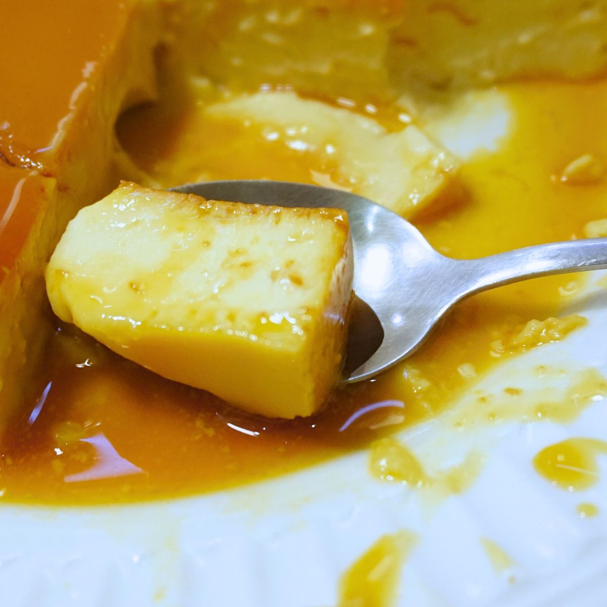 Scoop of leche flan in a spoon.