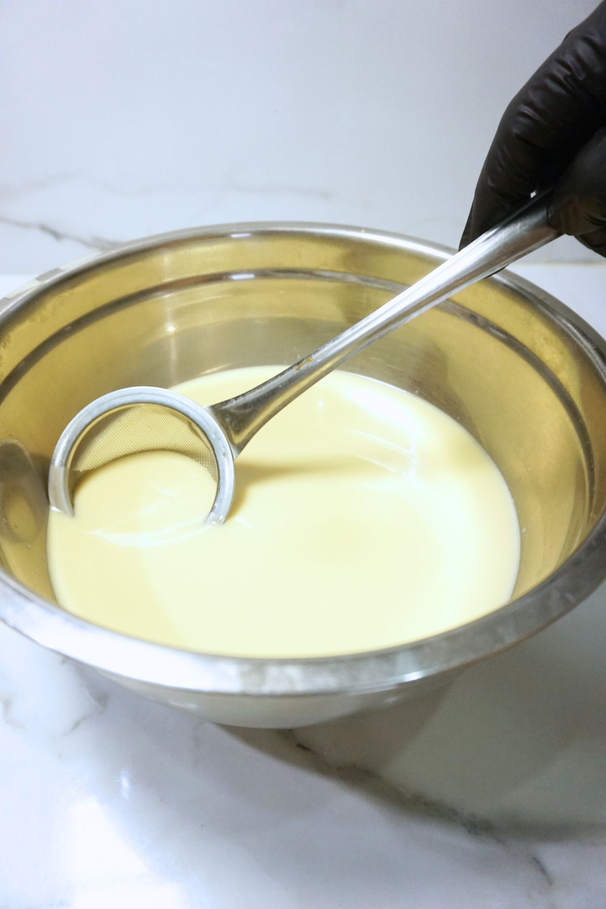 Bubbles removed from leche flan mixture