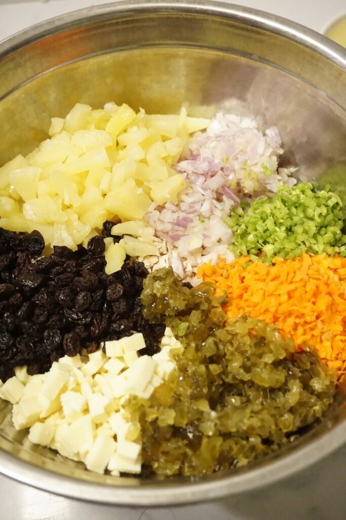 Macaroni salad ingredients in a metal bowl