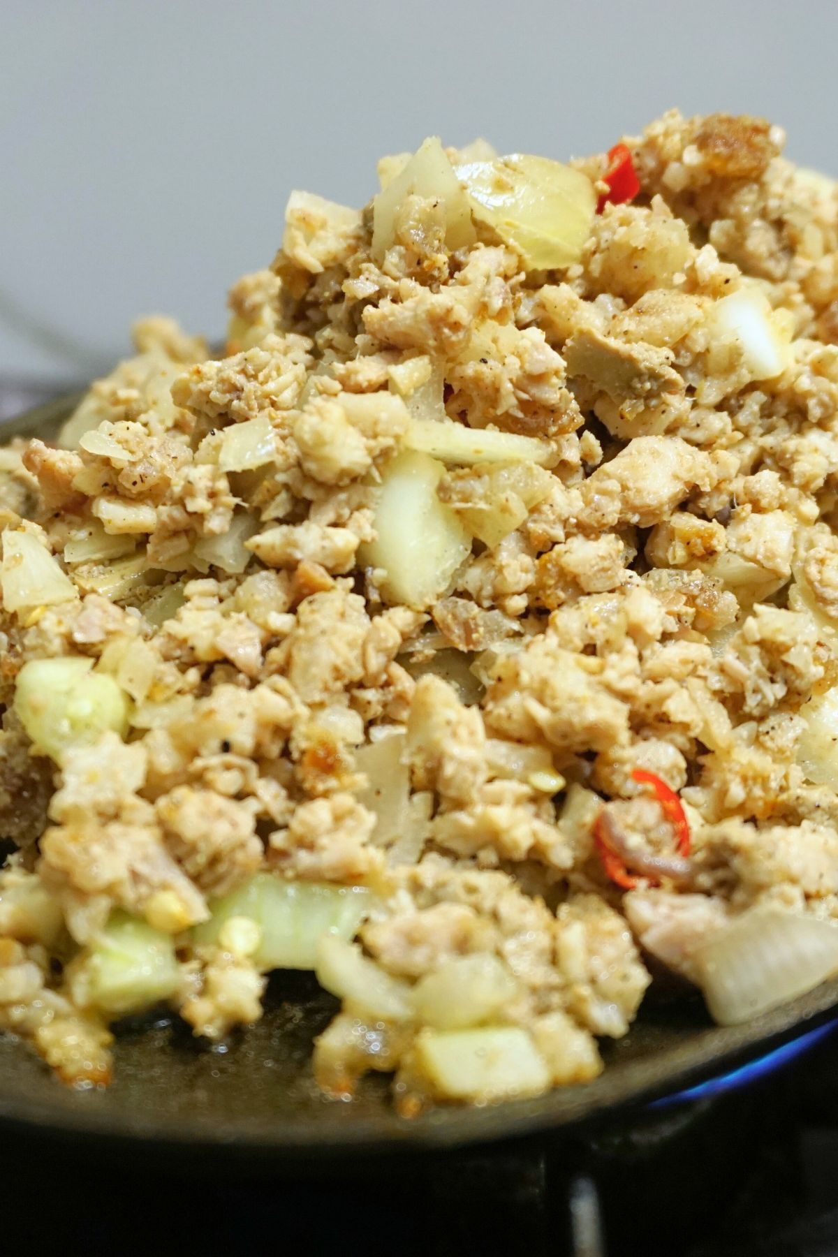 Sizzling pork sisig in a sizzling plate.