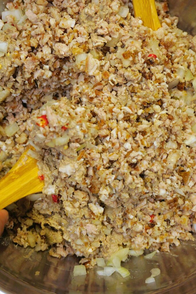 Pork sisig mixed in a metal bowl.