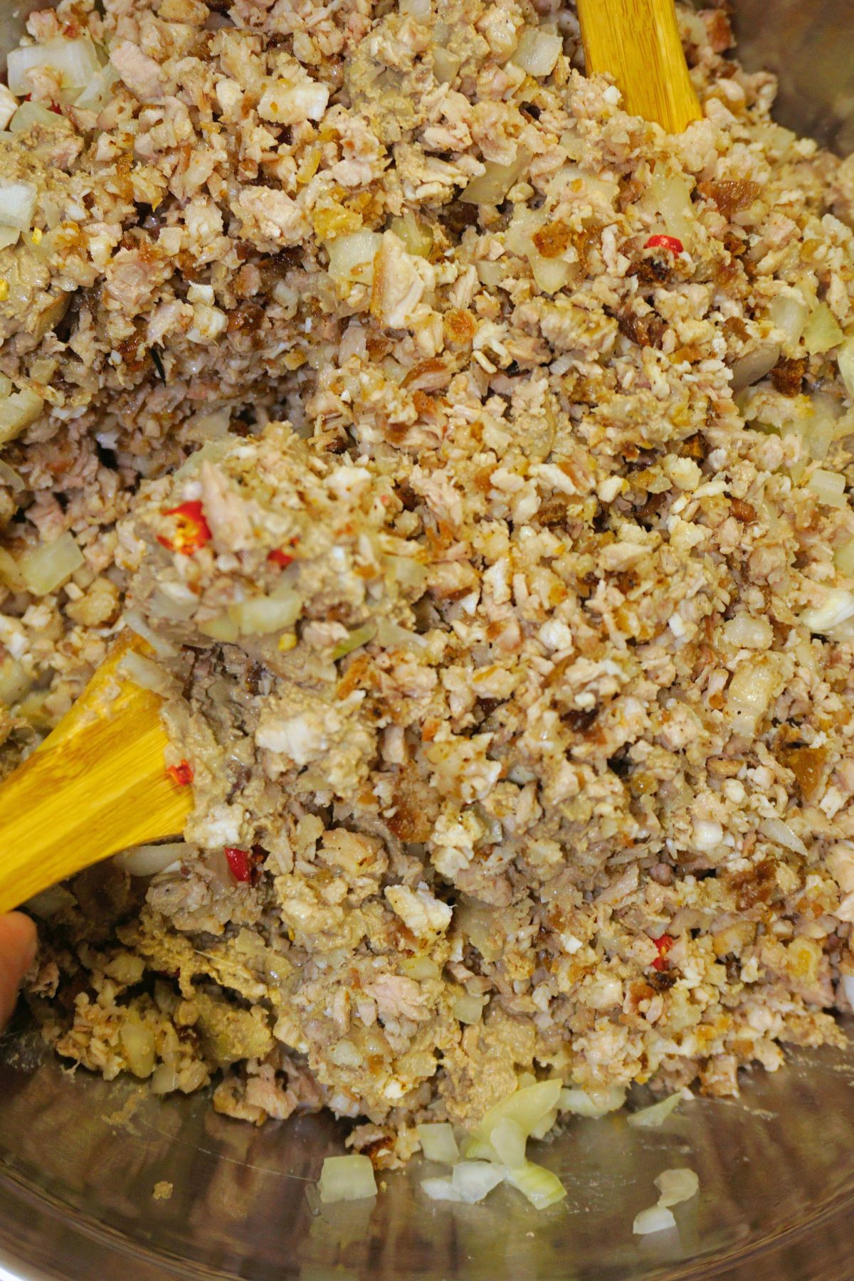 Pork sisig mixed in a metal bowl.